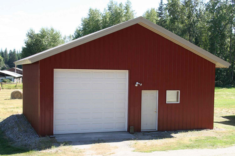Front view of a small red house with a white door and garage door